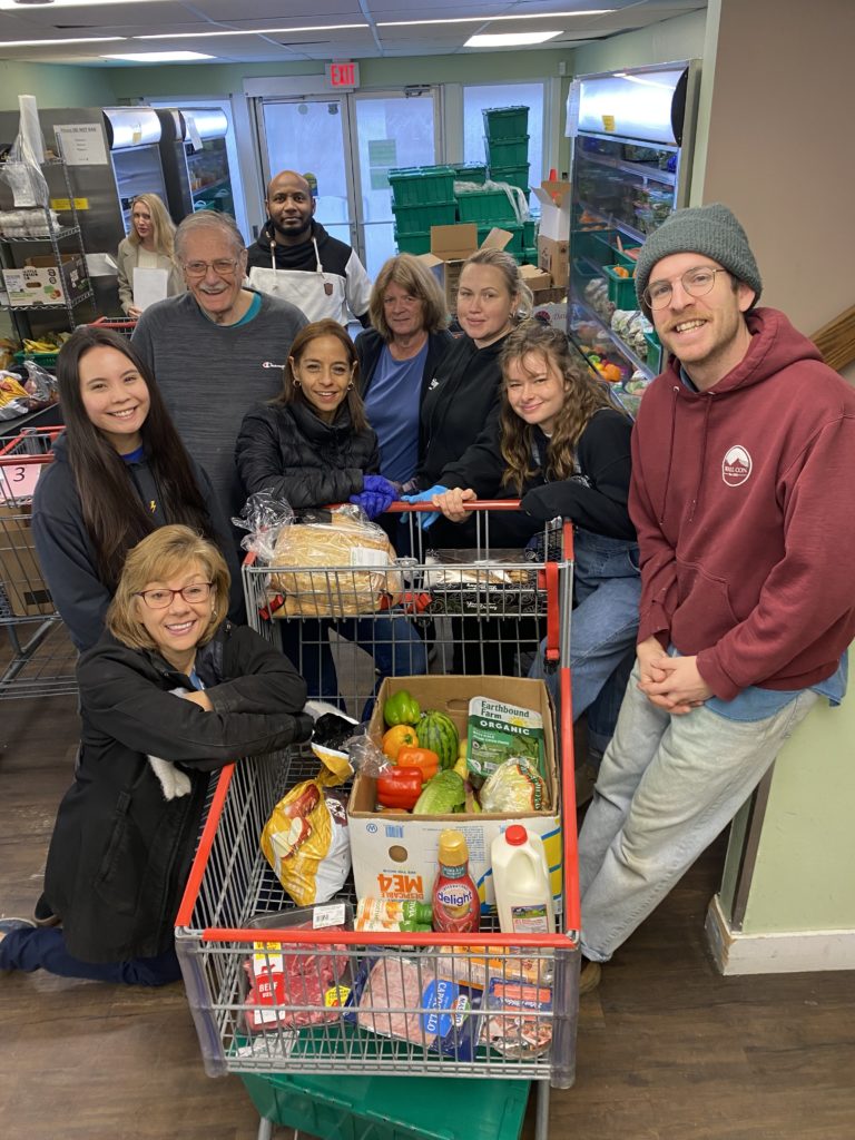 Food Bank Staff and Volunteers with a monthly hamper for a family of four.