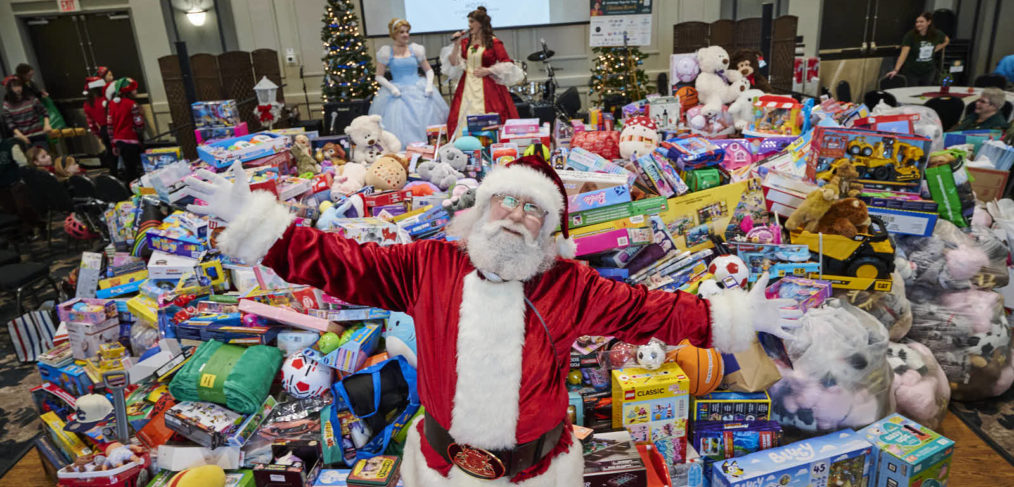 Santa in front of mountain of toys