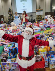 Santa in front of mountain of toys