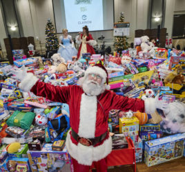 Santa in front of mountain of toys