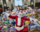 Santa in front of mountain of toys