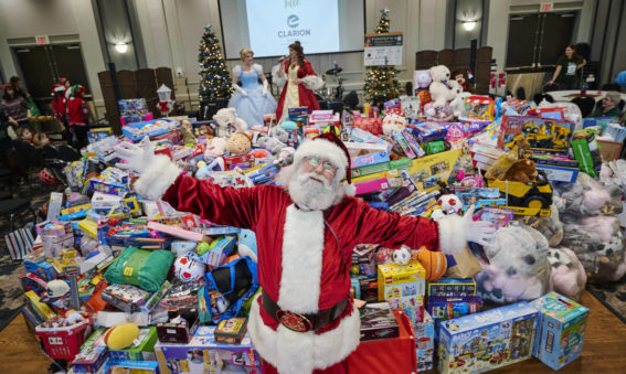 Santa in front of mountain of toys