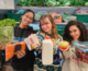 Three girls holding food items, posing for a picture